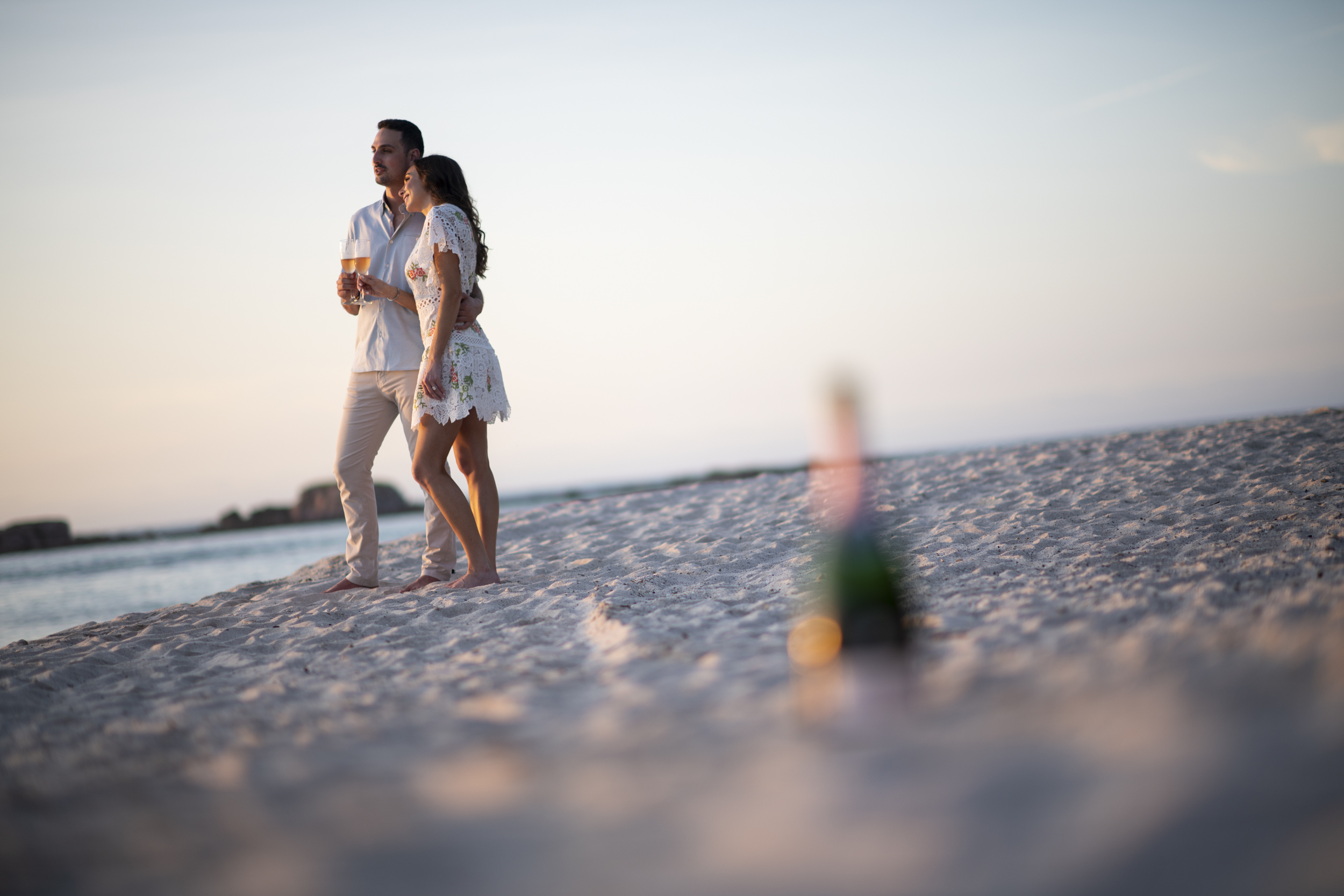 Pareja caminando por la playa con champán al atardecer, Punta Mita