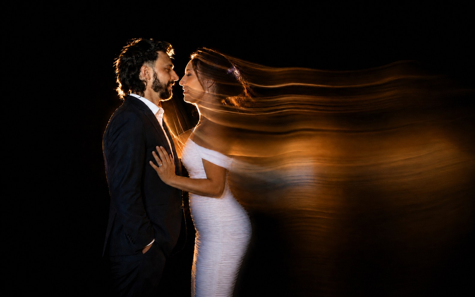 Wedding photographer in Puerto Vallarta — bride and groom with a trail of light sweeping through her veil