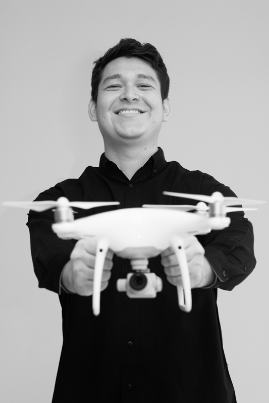 Drone pilot smiling, holding his drone